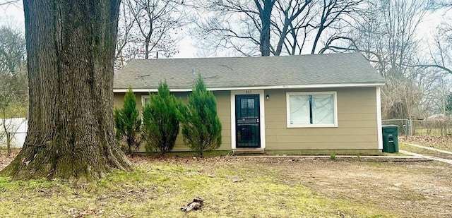 view of front of property with a shingled roof and fence