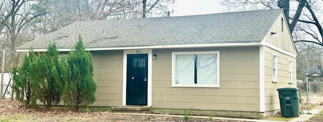 view of front of property with a shingled roof and fence