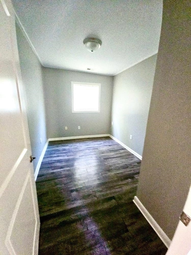 empty room with wood finished floors and baseboards