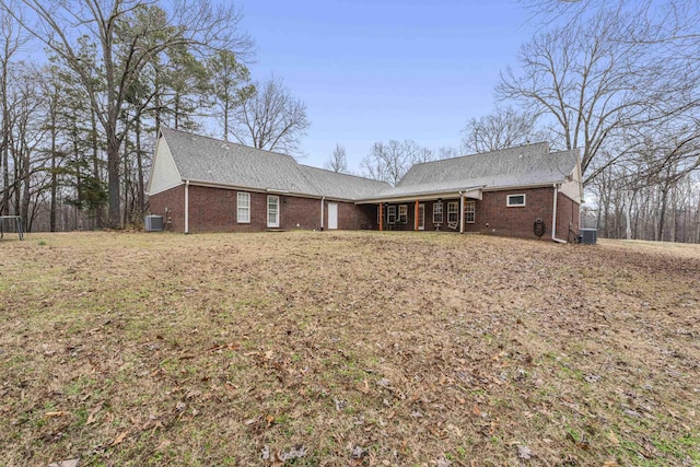 back of house featuring central air condition unit and brick siding