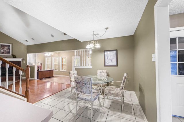 dining space featuring baseboards, visible vents, stairway, vaulted ceiling, and a textured ceiling