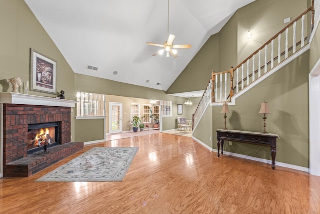 living area with baseboards, a fireplace, stairway, and wood finished floors