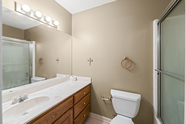 full bathroom featuring toilet, an enclosed shower, vanity, baseboards, and tile patterned floors