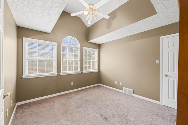 unfurnished room featuring lofted ceiling, carpet flooring, visible vents, and baseboards