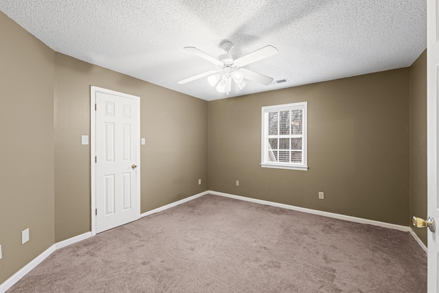 unfurnished room with baseboards, visible vents, ceiling fan, and carpet flooring