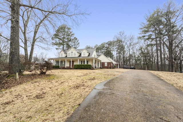 view of front of house featuring covered porch and brick siding