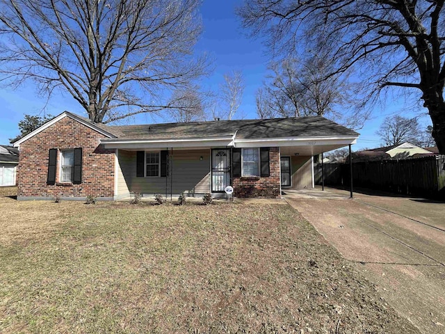 ranch-style home featuring concrete driveway, an attached carport, fence, a front lawn, and brick siding