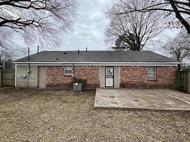 back of property with a patio area, brick siding, central AC unit, and fence