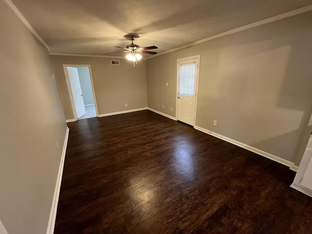 spare room featuring ornamental molding, dark wood-style flooring, a ceiling fan, and baseboards