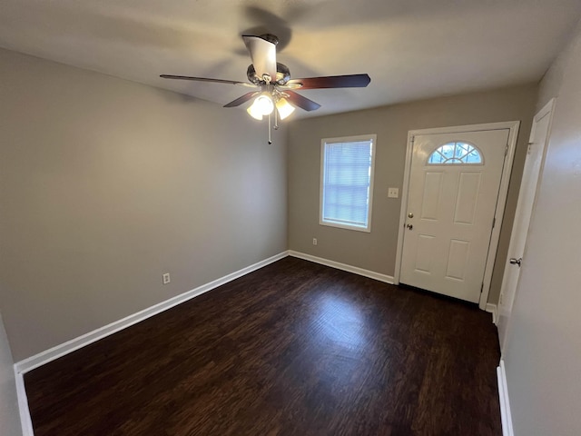 foyer entrance featuring a ceiling fan, baseboards, and dark wood-type flooring