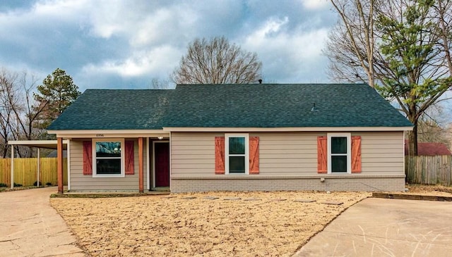 single story home with brick siding, roof with shingles, fence, an attached carport, and driveway