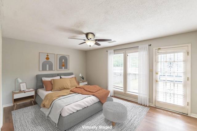 bedroom featuring visible vents, a ceiling fan, wood finished floors, access to exterior, and a textured ceiling