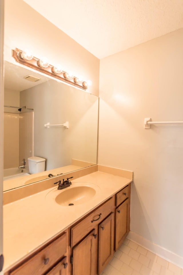 full bath with shower / bathing tub combination, toilet, vanity, baseboards, and tile patterned floors