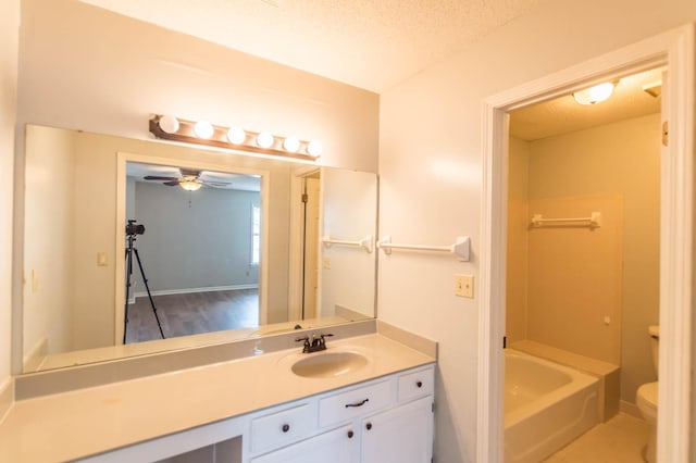 full bathroom featuring a textured ceiling, toilet, vanity, baseboards, and a bath