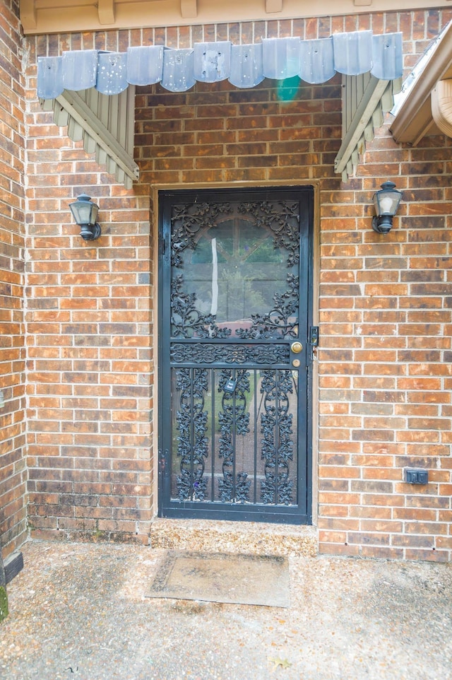 view of exterior entry with brick siding