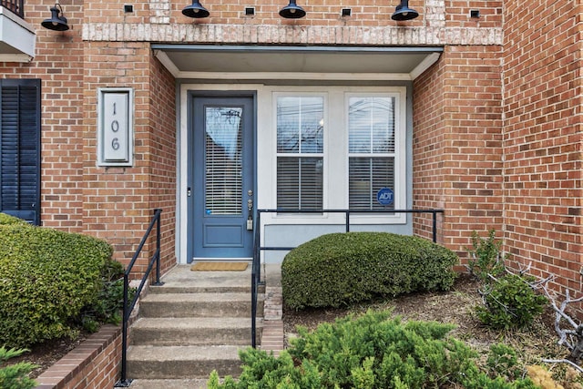 doorway to property featuring brick siding