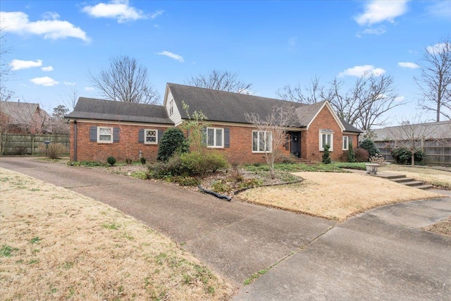 ranch-style house featuring fence and brick siding