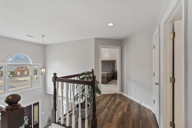 hall featuring baseboards, dark wood finished floors, an inviting chandelier, an upstairs landing, and recessed lighting