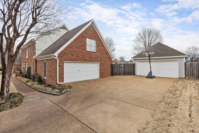 view of home's exterior featuring brick siding, fence, and roof with shingles