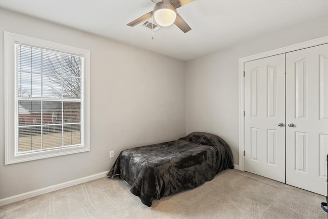 bedroom with a closet, carpet flooring, visible vents, and baseboards