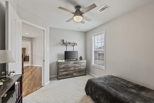 carpeted bedroom featuring baseboards, visible vents, and a ceiling fan