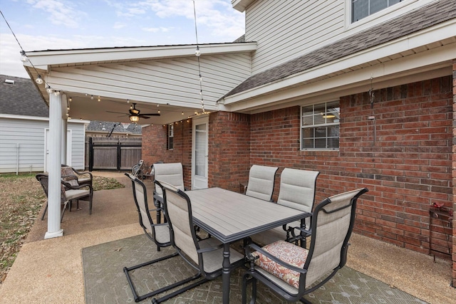 view of patio featuring ceiling fan, outdoor dining space, and fence