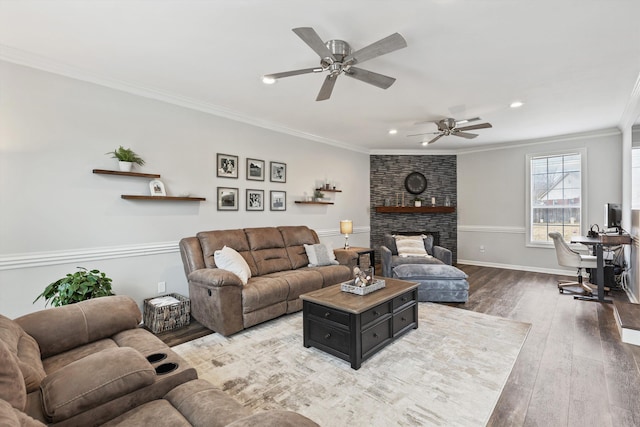 living room featuring recessed lighting, a large fireplace, wood finished floors, baseboards, and crown molding