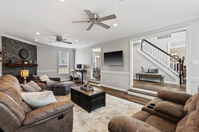 living area with crown molding, recessed lighting, visible vents, wood finished floors, and stairs