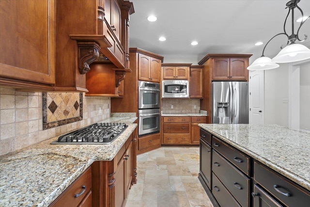 kitchen with appliances with stainless steel finishes, backsplash, light stone counters, and pendant lighting