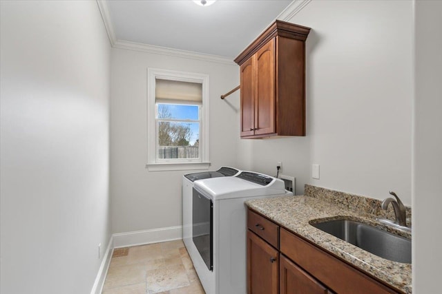 clothes washing area with crown molding, cabinet space, a sink, separate washer and dryer, and baseboards