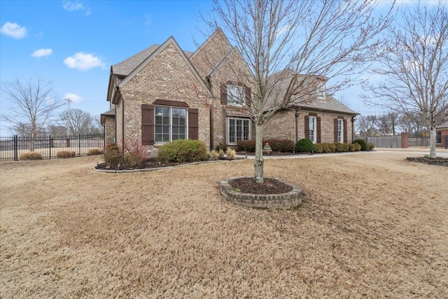 view of front of property with fence, a front lawn, and brick siding