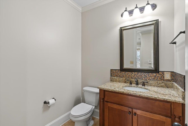 bathroom with toilet, vanity, baseboards, backsplash, and crown molding