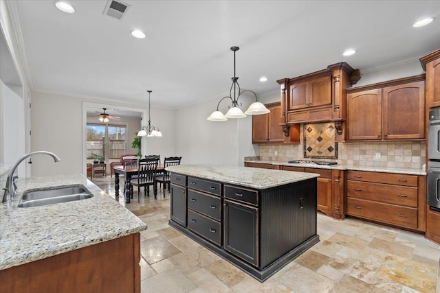 kitchen with ornamental molding, tasteful backsplash, a kitchen island, and a sink