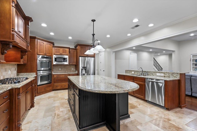 kitchen with visible vents, ornamental molding, a center island, stainless steel appliances, and a sink