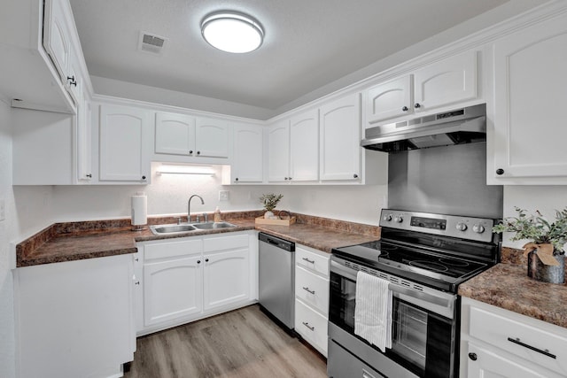 kitchen with visible vents, appliances with stainless steel finishes, white cabinets, a sink, and under cabinet range hood