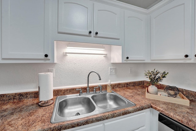 kitchen with dishwasher, white cabinets, and a sink