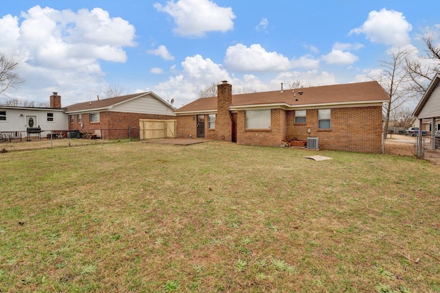 rear view of house featuring a fenced backyard, a chimney, a gate, a yard, and brick siding