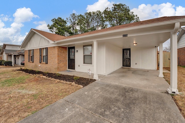 ranch-style home featuring driveway, an attached carport, and brick siding