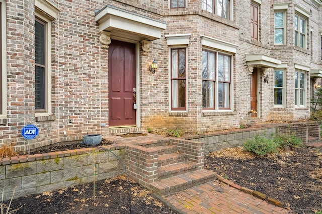 doorway to property featuring brick siding