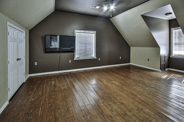 bonus room with visible vents, ceiling fan, vaulted ceiling, baseboards, and hardwood / wood-style flooring