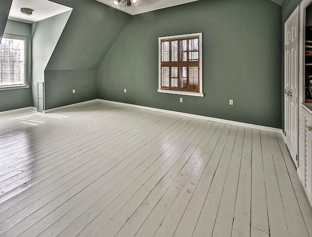 additional living space featuring lofted ceiling, wood-type flooring, and baseboards