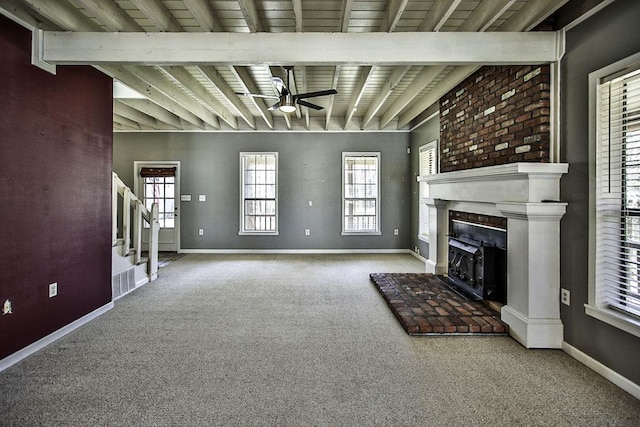 unfurnished living room with beam ceiling, plenty of natural light, and baseboards