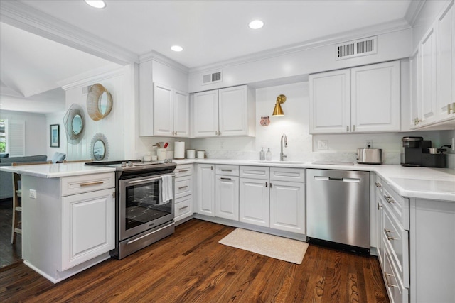 kitchen featuring appliances with stainless steel finishes, visible vents, a sink, and a peninsula