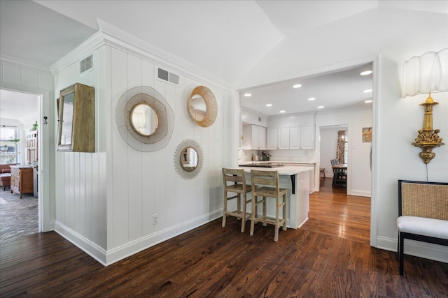 kitchen with light countertops, white cabinets, visible vents, and a peninsula