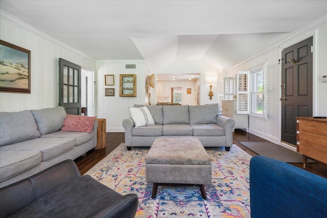 living area featuring wood finished floors, visible vents, baseboards, vaulted ceiling, and crown molding