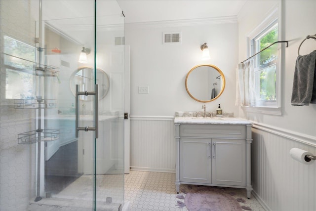 full bath featuring a stall shower, wainscoting, visible vents, and crown molding