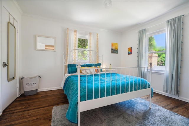 bedroom featuring crown molding, baseboards, and wood finished floors