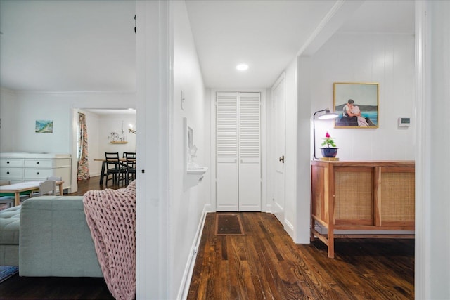 hallway featuring crown molding, baseboards, and dark wood-type flooring