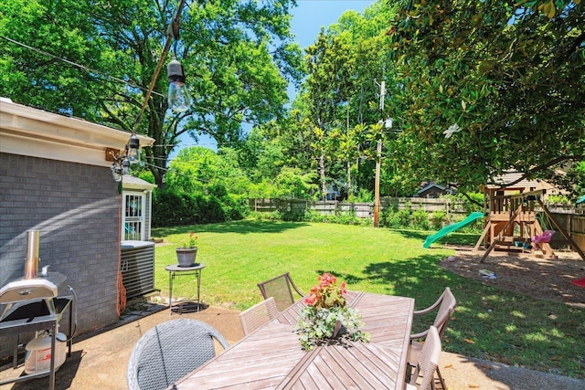 view of patio / terrace with a playground, central air condition unit, outdoor dining space, a grill, and a fenced backyard