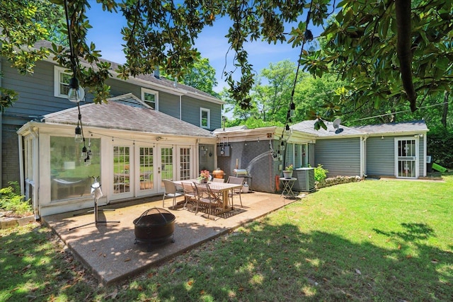 back of property featuring french doors, a patio, a lawn, central AC, and a fire pit